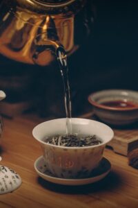 Artistic depiction of a traditional Chinese tea ceremony with porcelain teaware and hot water pour.