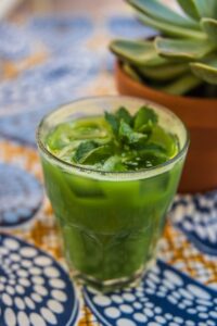 Delight in a refreshing green mint iced tea with vibrant colors set in a lively atmosphere.